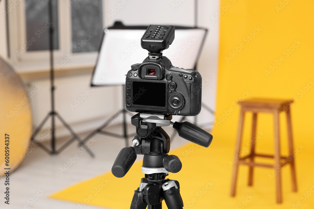 Camera on tripod, bar stool and professional lighting equipment in modern photo studio Camera on tripod, bar stool and professional lighting equipment in modern photo studio