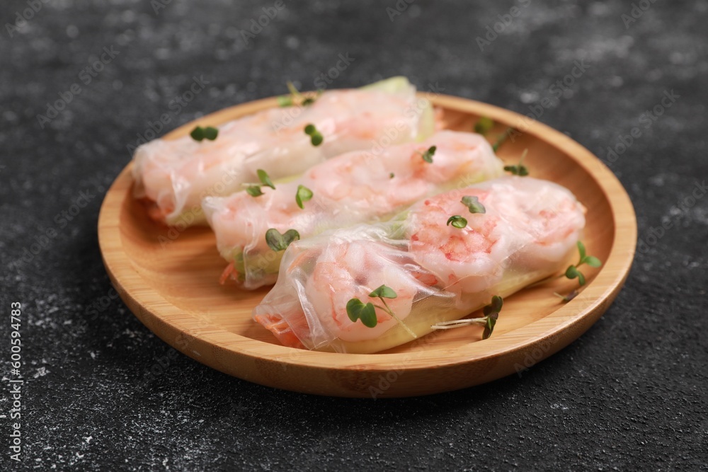 Plate with tasty spring rolls and microgreens on grey textured table, closeup