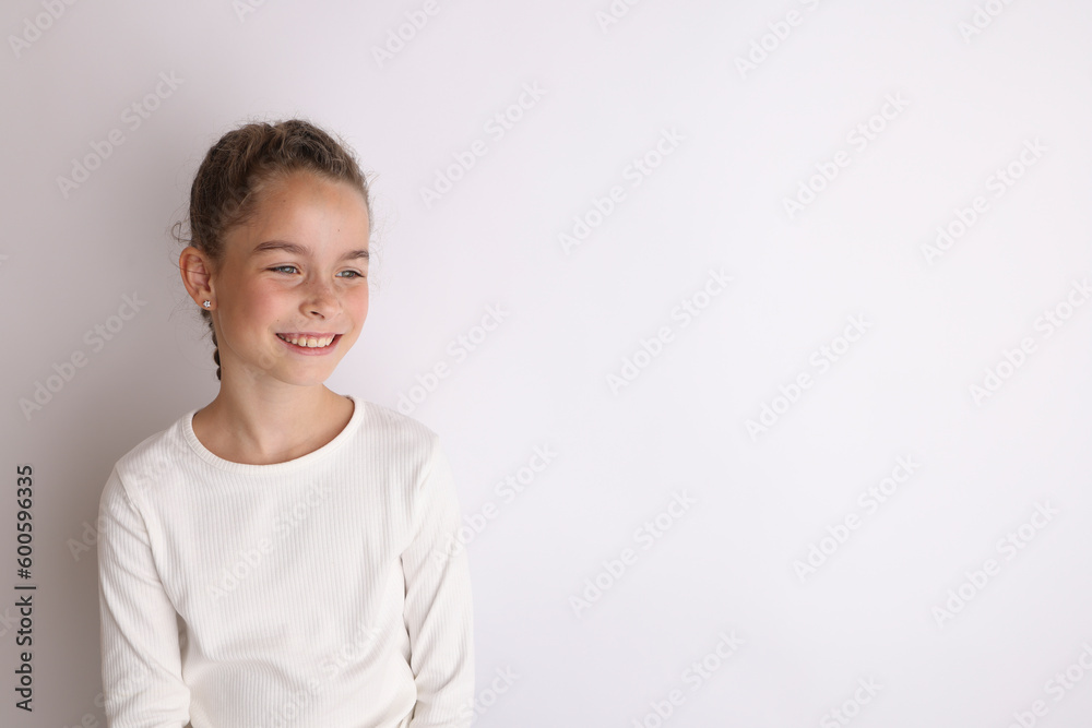 Little emotional teen girl in white shirt on an isolated white background. Little emotional teen girl in white shirt on an isolated white background.