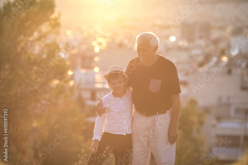 Grandfather and grandson enjoying outdoor, smiling and hugging. Concept of friendly family.