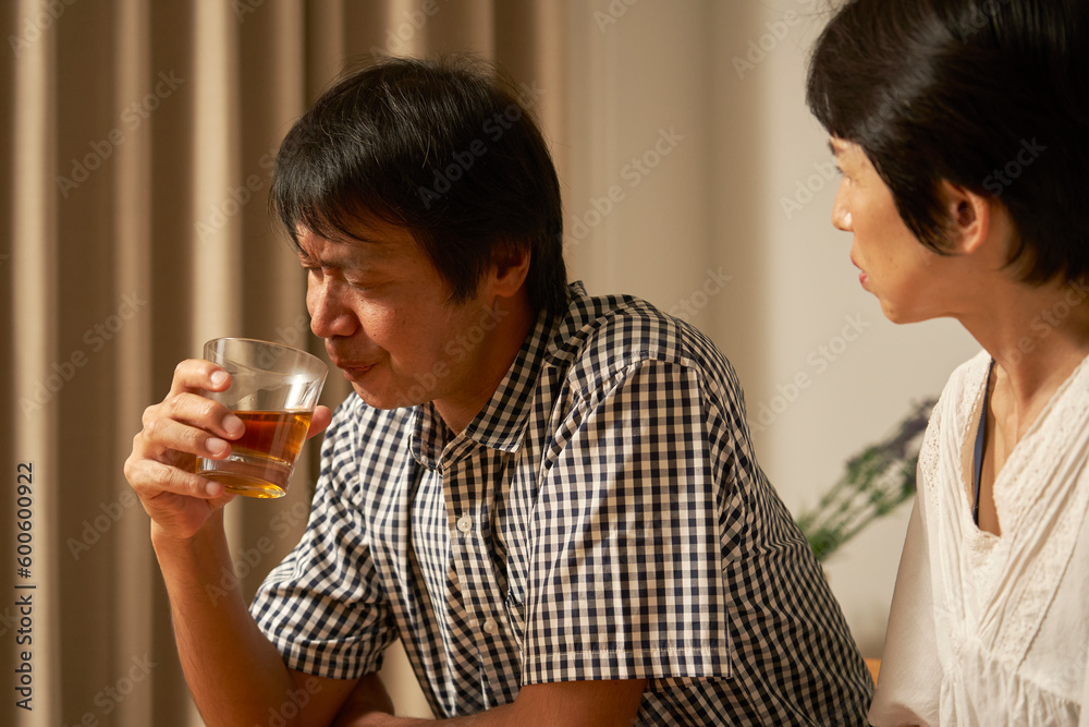 自宅で落ち込む中年男性 自宅で落ち込む中年男性