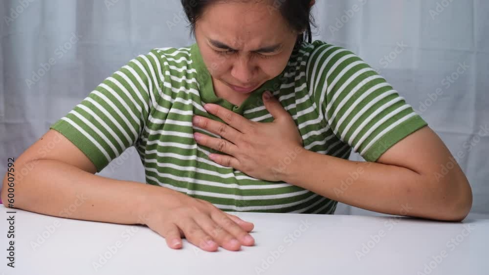 Woman holding her chest with pain expression. Women have chest pain