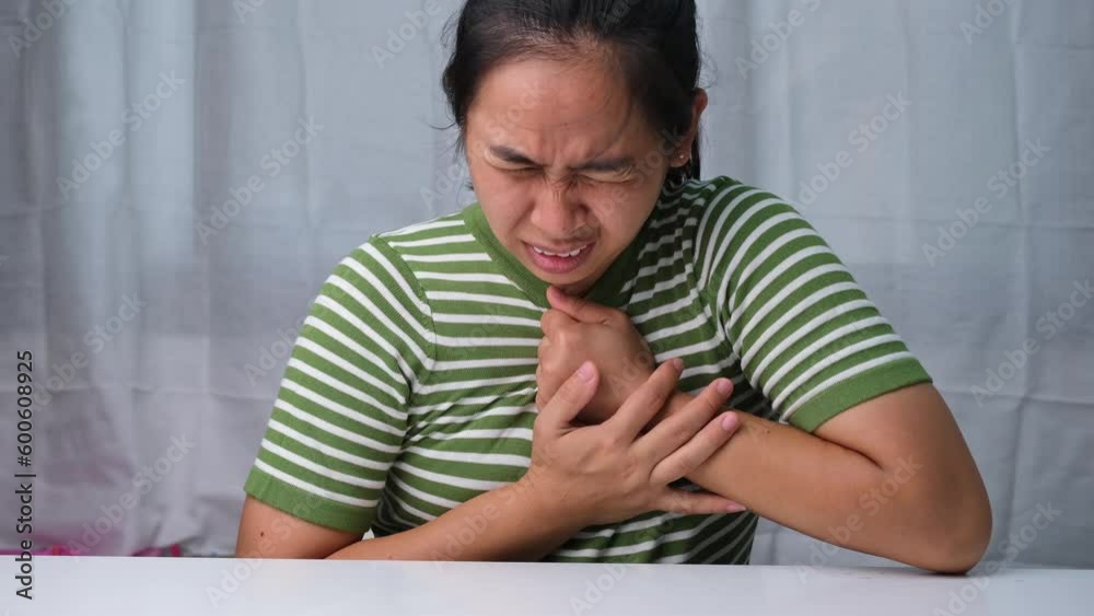 Woman holding her chest with pain expression. Women have chest pain caused by heart disease, heart attack, heart leak or coronary artery disease. Woman holding her chest with pain expression. Women have chest pain caused by heart disease, heart attack, heart leak or coronary artery disease.