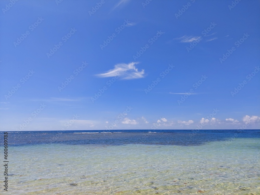 Shallow coast waters with blue sky background