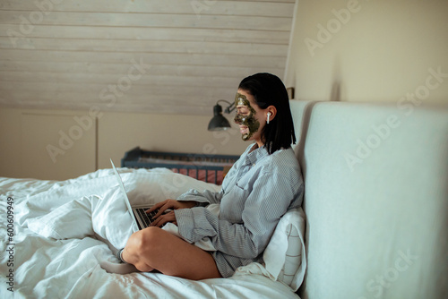 Young woman using her laptop in the bedroom