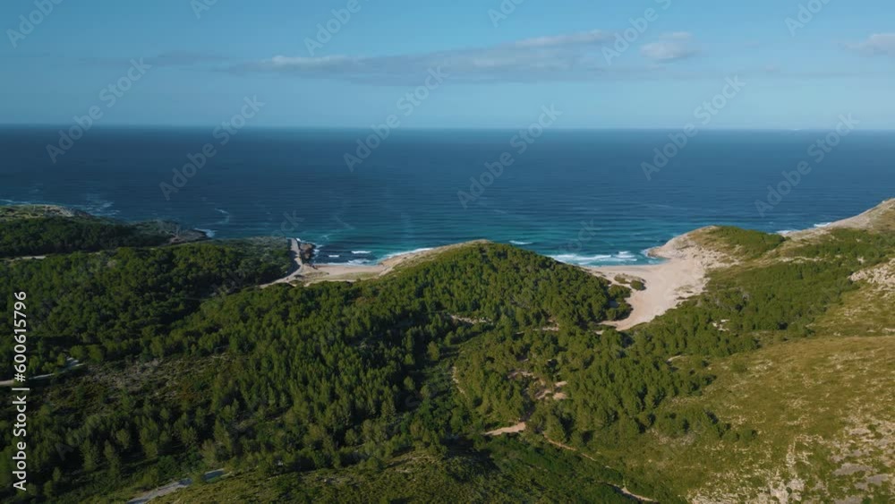 Beautiful beach bay with green hills, clear turquoise sea water, white sand. Serra de Tramuntana, Palma de Mallorca Island. Balearic Majorca seaside coast. Cinematic vacation. Aerial drone 4K UHD.
