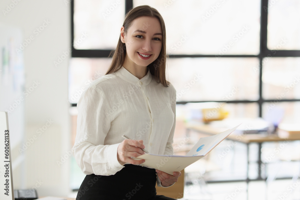 Smiling woman holding statististics documents with charts and graphs Smiling woman holding statististics documents with charts and graphs