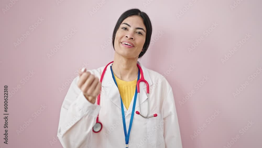 Young beautiful hispanic woman doctor smiling confident blowing kiss over isolated pink background Young beautiful hispanic woman doctor smiling confident blowing kiss over isolated pink background