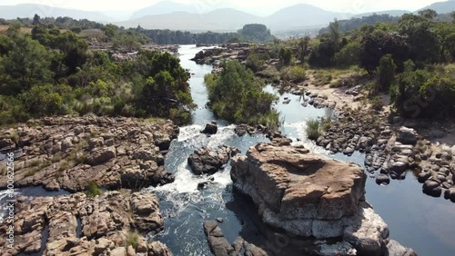 Flying Above Scenic River Flowing Through Rocks In The Drakensberg Mountains In South Africa. aerial photo