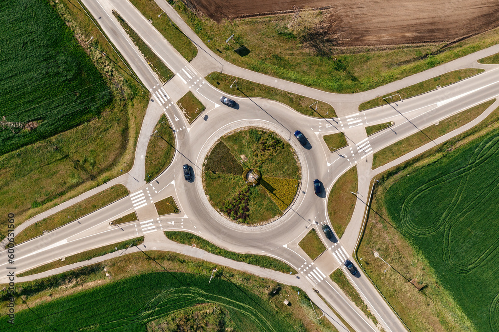 Roundabout intersection road traffic with many cars, aerial shot from drone pov