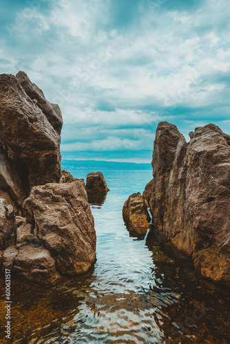Kvarner gulf of Adriatic sea rocky coastline, large rocks at shoreline in old town of Lovran in Croatia