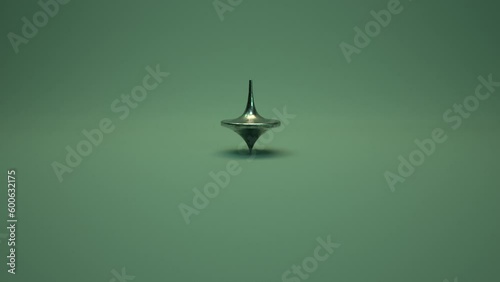Spinning Top.  A weathered metal spinning top spins, slows, wobbles, falls and stops as camera pushes in.
