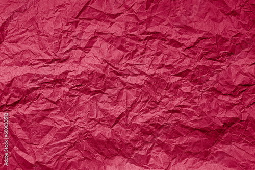 Natural abstract textured background of wrinkled paper of viva magenta color of the year 2023.