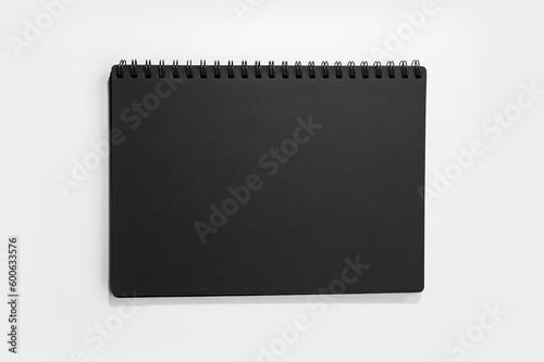 Close-up of black closed notebook with mockup isolated on white background.