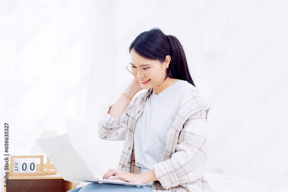 Asian woman enjoying the work she does in the happy bedroom Asian woman enjoying the work she does in the happy bedroom