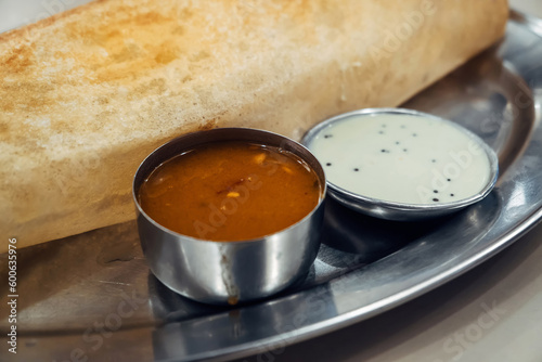 Crispy Masala dosa on iron plate. Dosa is a popular South Indian food item served with coconut chutney and sambar. Copy space. Cruncy Rice crepes photo