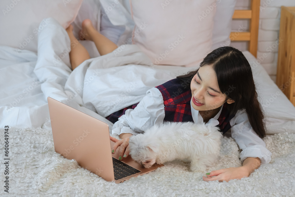 Beautiful asian woman's smile reflected the joy and comfort that came from having her furry friend by her side even as she tackled her work. Beautiful asian woman's smile reflected the joy and comfort that came from having her furry friend by her side even as she tackled her work.
