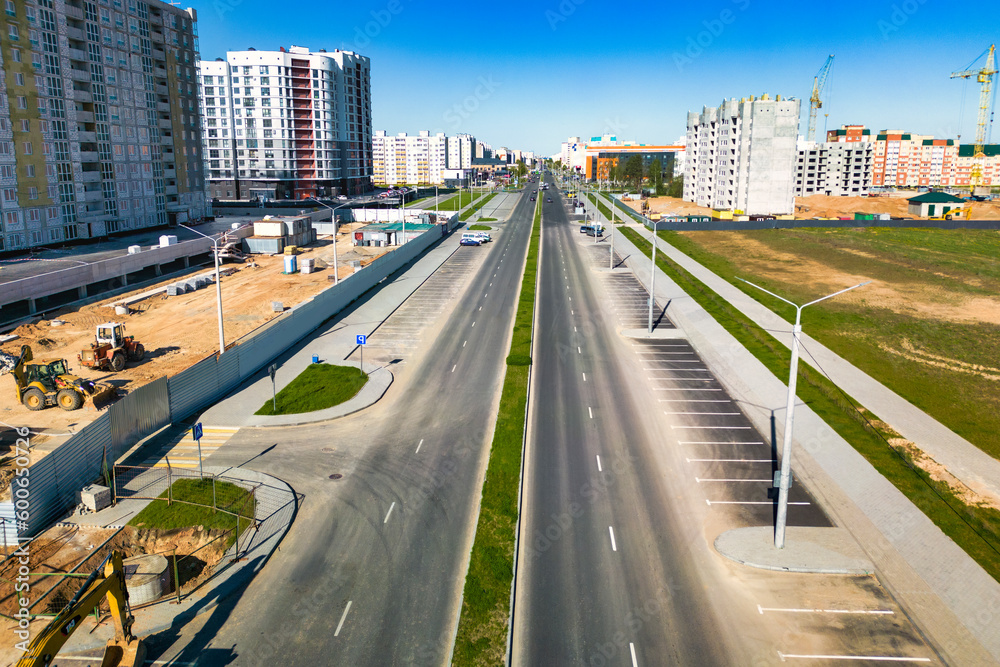 Construction of new roads and sidewalks in the city. View from above. Construction of a new modern area. Improvement of the territory and access roads. Road works from above.