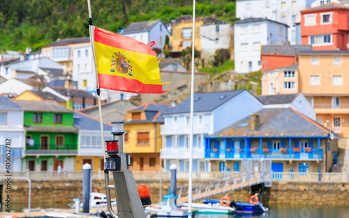 Spanish flag in galicia village with colorful houses- Travel in Spain