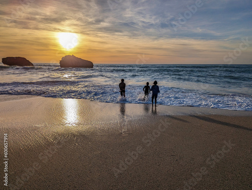 Crianças a brincarem junto à praia ao entardecer no País Basco, França photo
