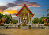Beautiful Wat Buddhist temples in Phuket Thailand. light up at night and Decorated in beautiful ornate colours of red and Gold and Blue. Lovely sunset