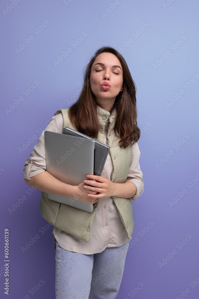 positive 30s woman office employee with a stack of documents and a laptop in her hands positive 30s woman office employee with a stack of documents and a laptop in her hands