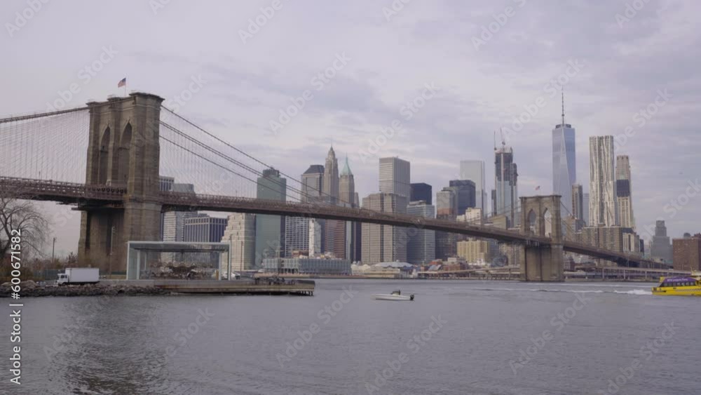 Lockdown Shot Of Brooklyn Bridge Over East River Near Buildings In City Against Cloudy Sky At Dawn - New York City, New York Lockdown Shot Of Brooklyn Bridge Over East River Near Buildings In City Against Cloudy Sky At Dawn - New York City, New York
