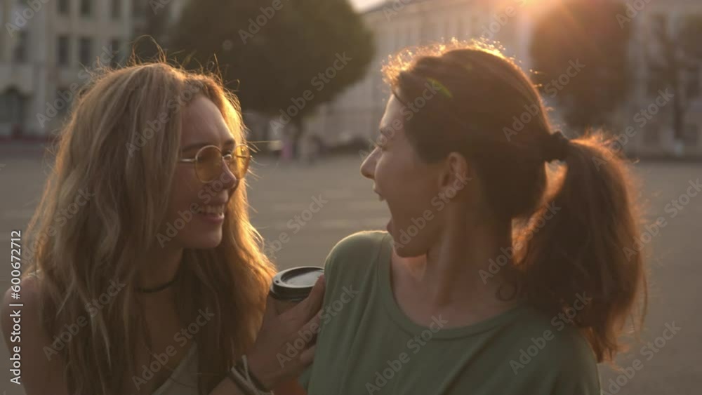 Two female friends hug and embrace outside, real life happiness reunion Two female friends hug and embrace outside, real life happiness reunion