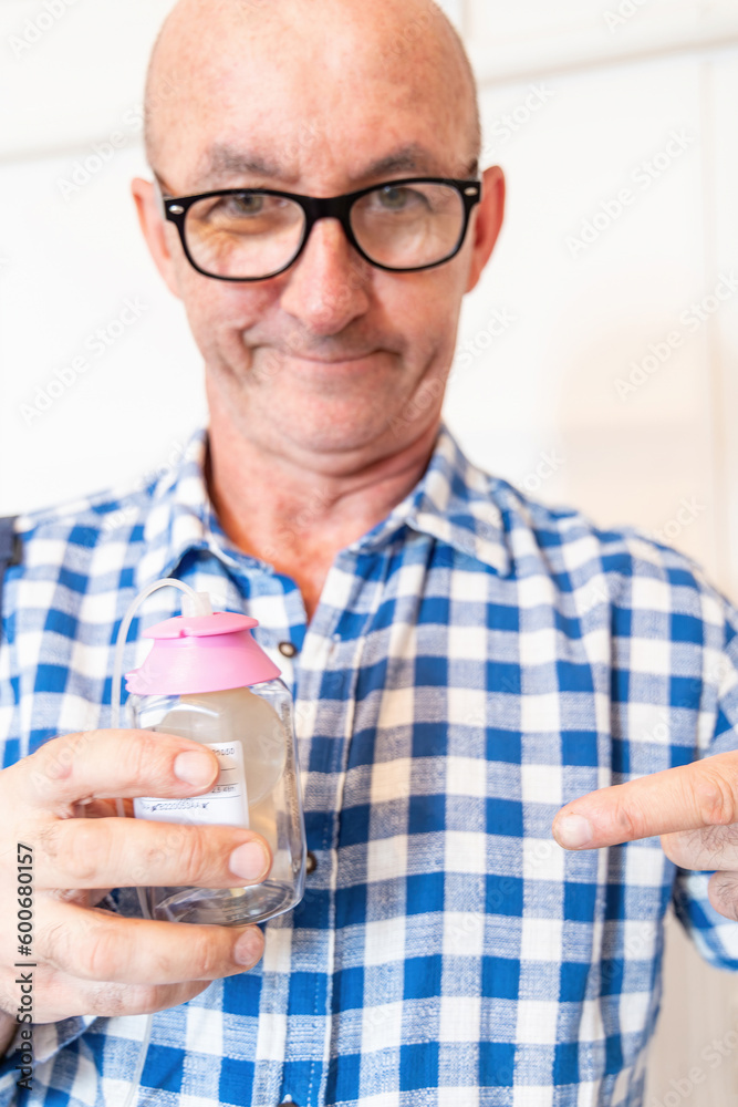 A man demonstrates a tube with a valve and a hinged connection for ...