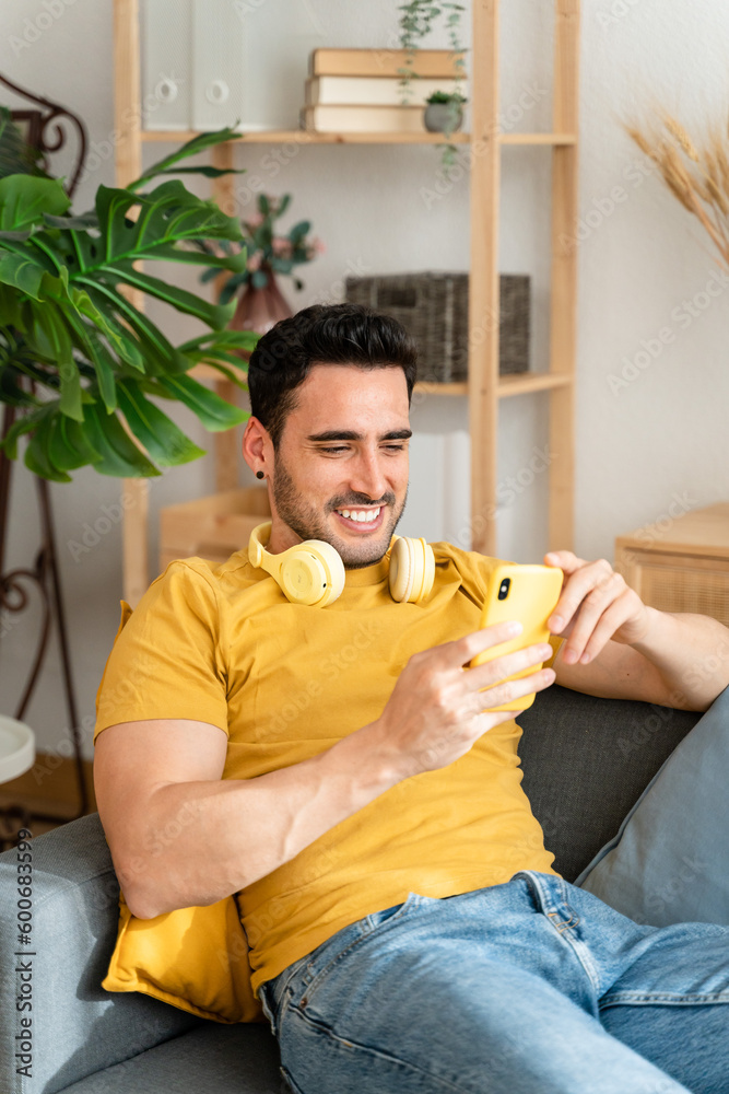 Man using cell phone while relaxing at home. Man using cell phone while relaxing at home.