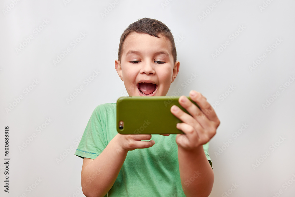 A handsome, cheerful guy is emotionally playing a game on a smartphone. A handsome, cheerful guy is emotionally playing a game on a smartphone.