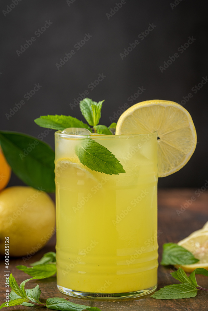 Lemonade with fresh mint leaves and lemon slice in glass glass on wooden table Lemonade with fresh mint leaves and lemon slice in glass glass on wooden table