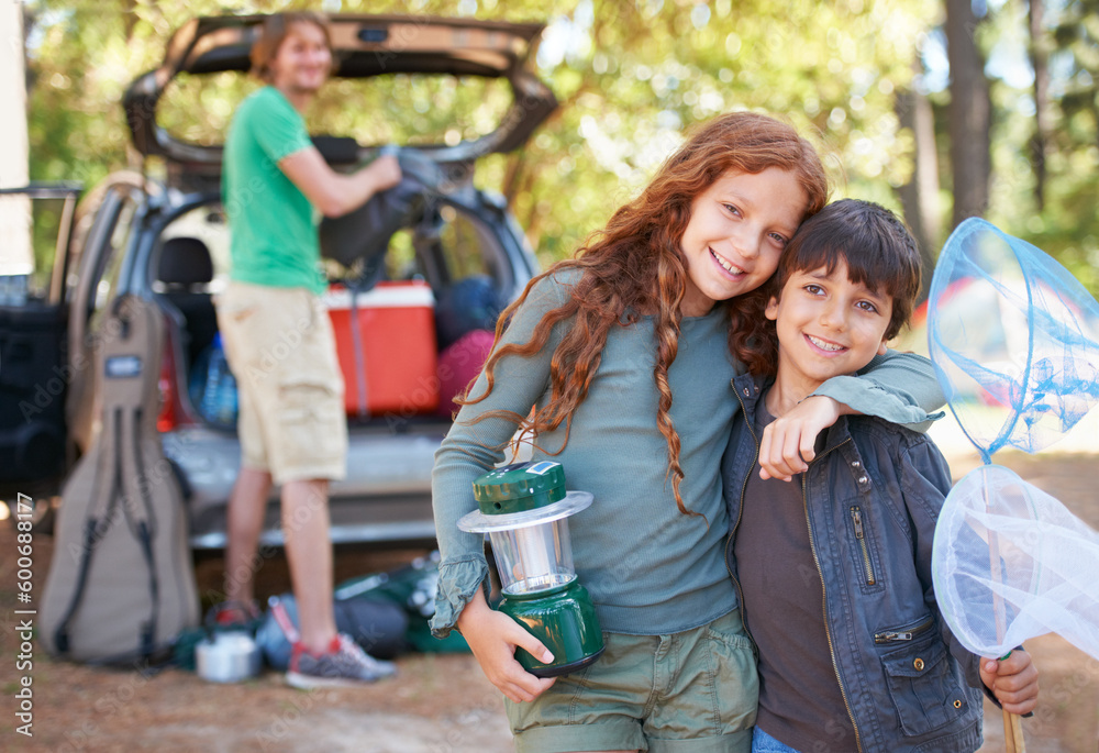 Fototapeta premium Happy siblings, portrait and hug for camping holiday, road trip or family vacation together in nature. Sister hugging brother with smile and lantern for camp adventure, travel or getaway in forest