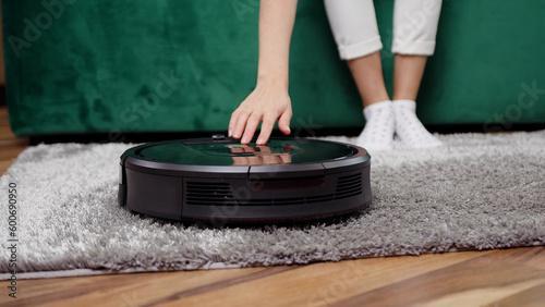 Close up of modern cleaning device helping to clean the carpet in the apartment photo