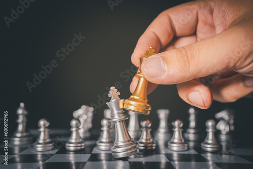 hand of businessman moving chess figure in competition success play. strategy,teamwork, management or leadership concept.