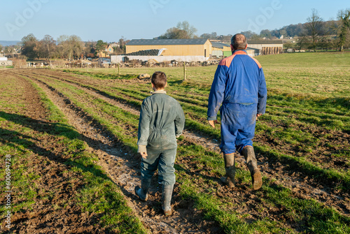 Agriculteur et son jeune fils marchant sur un chemin de la feme