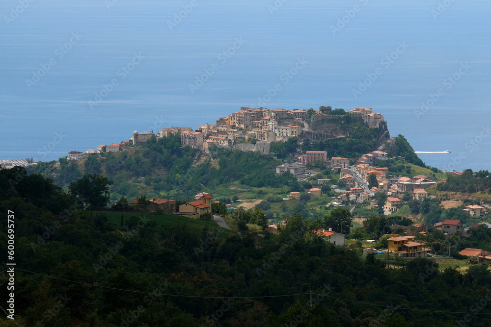 Island in Belvedere Marittimo, Calabria, Italy, covered by lush trees and seascape in the background