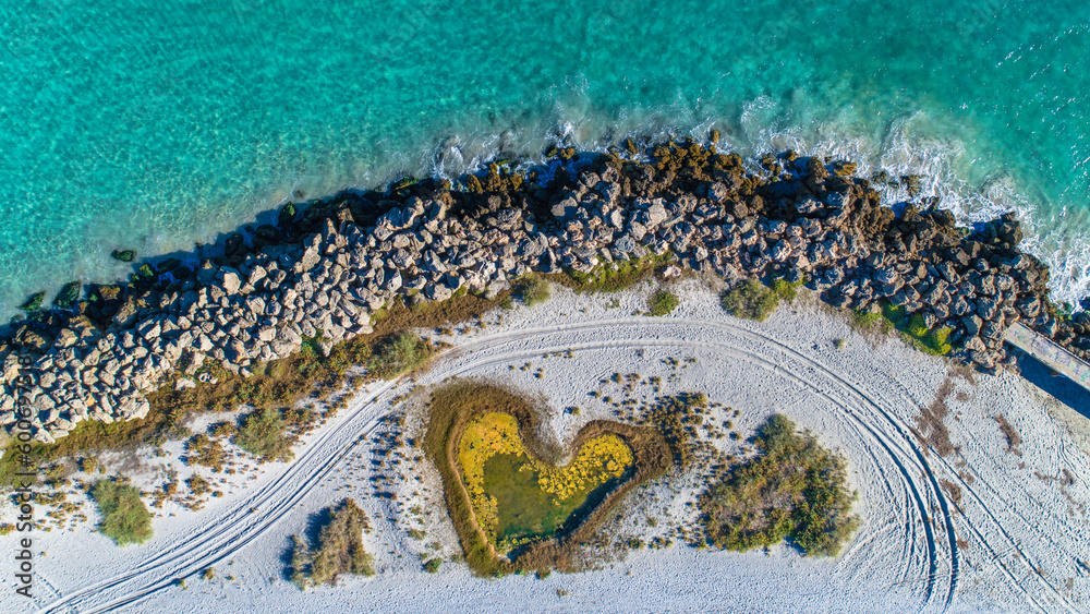 Aerial view of love heart shaped island and sandy beach. Sunny day in summer with romantic tropical blue water. Travel to love beach, Western Australia. Top view. Coastal, Seascape