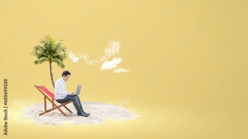 Asian businessman sitting on the beach chair while using a laptop