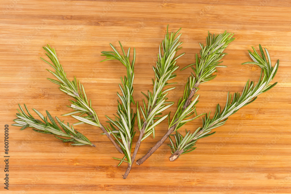 Fresh rosemary twigs on a cutting board Fresh rosemary twigs on a cutting board
