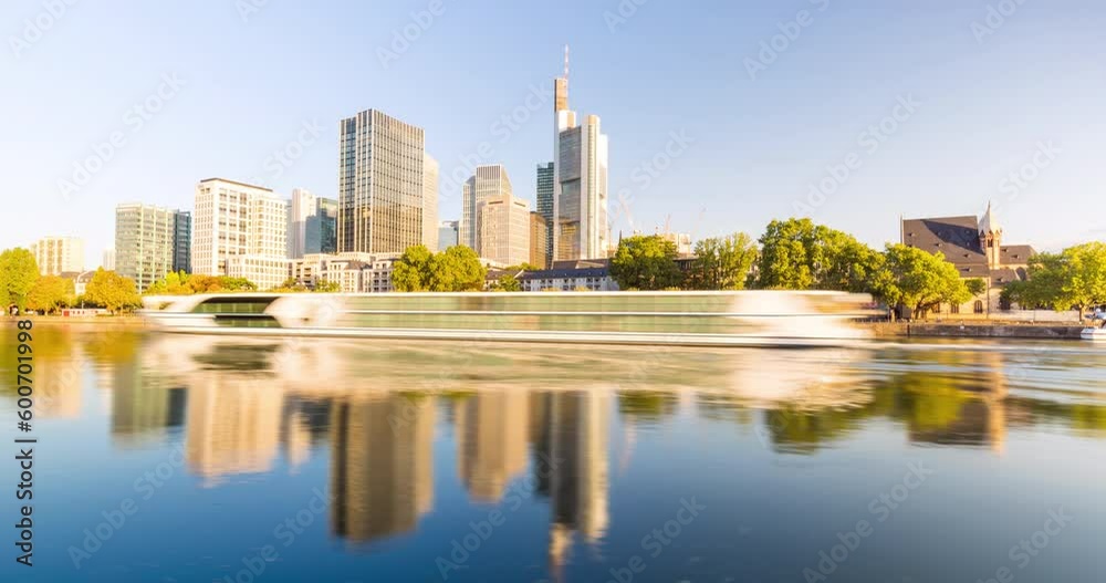 Frankfurt city skyline hyperlapse in 4k. Moving shot along the main river on a sunny day with blue sky. View of the iconic skyline of europes financial capital of the euro zone. Frankfurt city skyline hyperlapse in 4k. Moving shot along the main river on a sunny day with blue sky. View of the iconic skyline of europes financial capital of the euro zone.