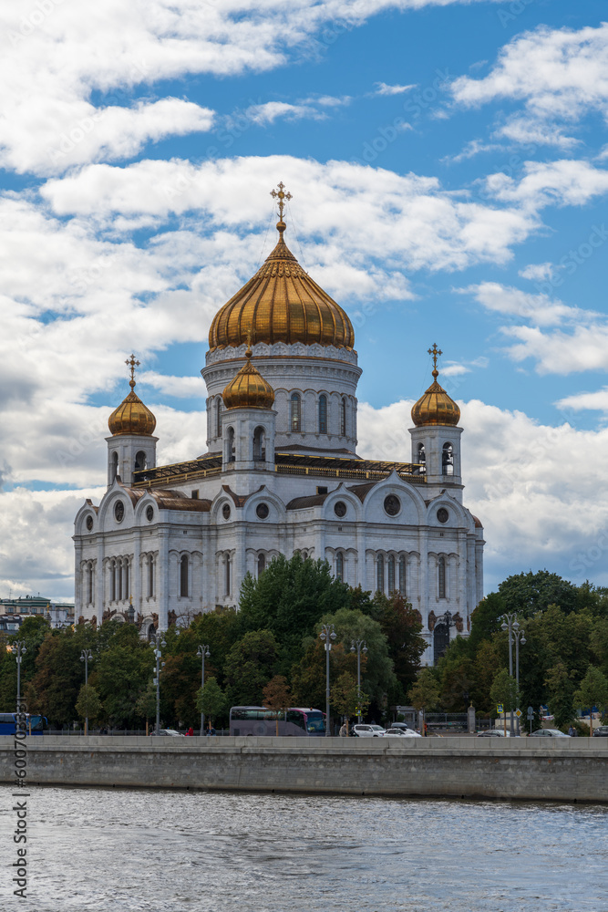 Side view of Cathedral of Christ the Saviour standing on Moscva river embankment. Blue sky with white clouds. Religious architecture. Travel in Russia theme.