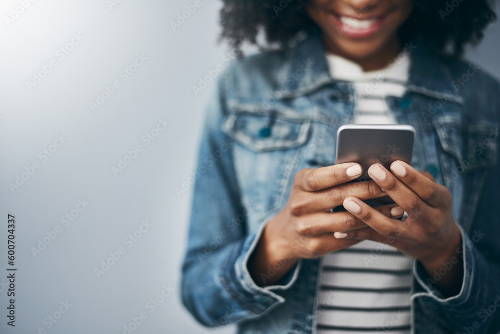 Hands, phone and woman with texting by wall background with smile, mock up space or meme on web chat. Gen z girl, smartphone or happy for blog, post or video on social network app for communication