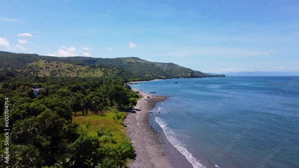 Aerial landscape view rising over green tree lined coastal shoreline, sandy beach and ocean and popular diving destination of Atauro Island in Timor-Leste Aerial landscape view rising over green tree lined coastal shoreline, sandy beach and ocean and popular diving destination of Atauro Island in Timor-Leste
