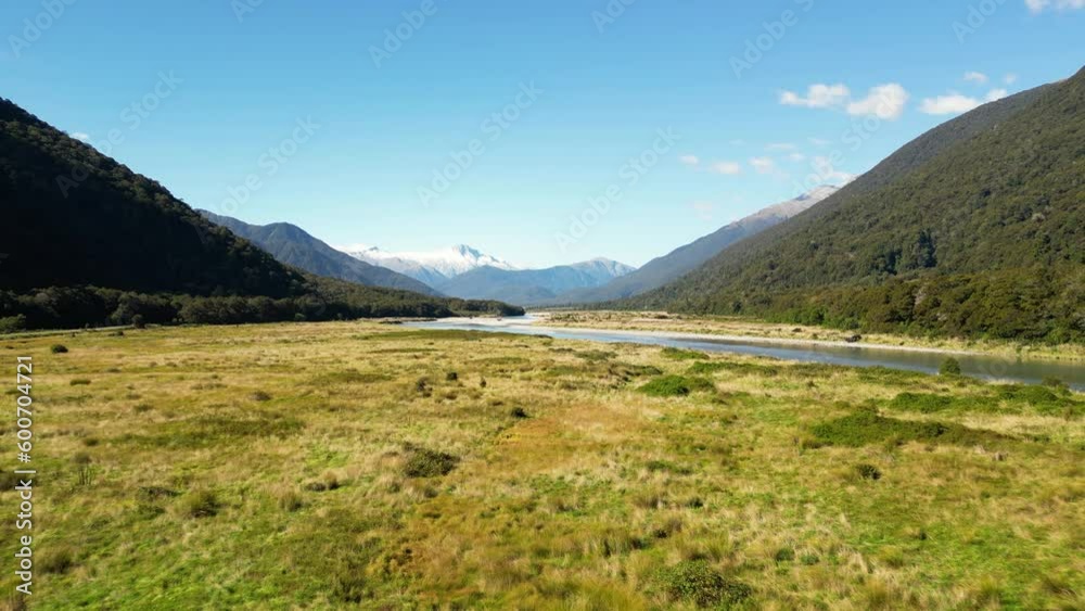 A flight close the the grass between the mountains in a valley close to the glacier at Pleasant Flat Campsite. River Haast is running nearby. A flight close the the grass between the mountains in a valley close to the glacier at Pleasant Flat Campsite. River Haast is running nearby.