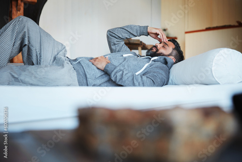 Quadro em tela Tired, sleep and a man with a headache on a bed with burnout, looking sad and depressed