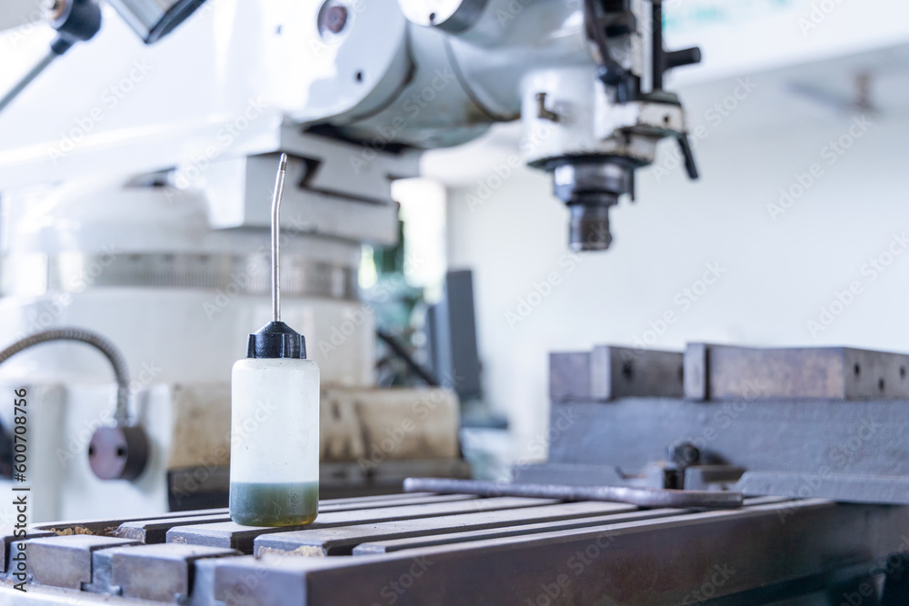 Sewing machine oil bottle for home and high professional sewing machine with drill press in factory or industrial plant. Sewing machine oil bottle for home and high professional sewing machine with drill press in factory or industrial plant.