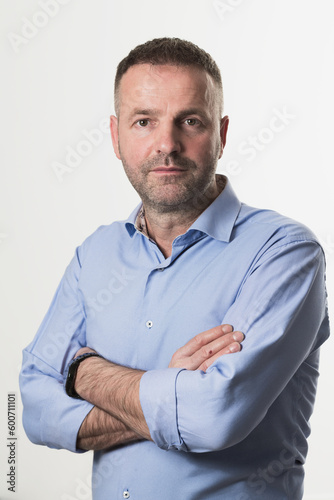 casual businessman wearing formal business clothes smiling at camera with crossed hands isolated over gray background.