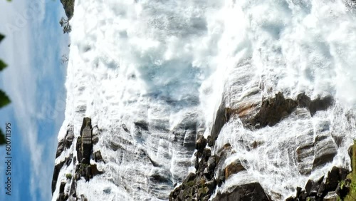 Kinsarvik, Hordaland, Norway. Waterfall Nyastolfossen In Hardangervidda Mountain Plateau. Nyastolsfossen in Spring Sunny Day. Famous Landmark. Slow motion, Slow-mo Video. Vertical Footage Video. photo