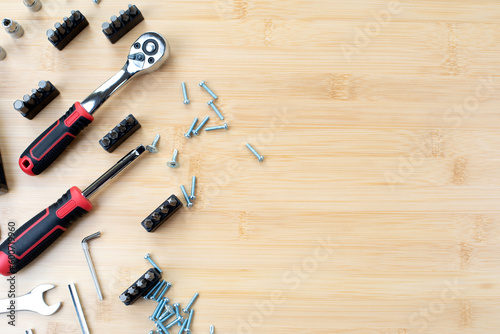 A set of working tools, a hammer, a screwdriver, sockets for repair on a bamboo, wooden background. Flat lay
